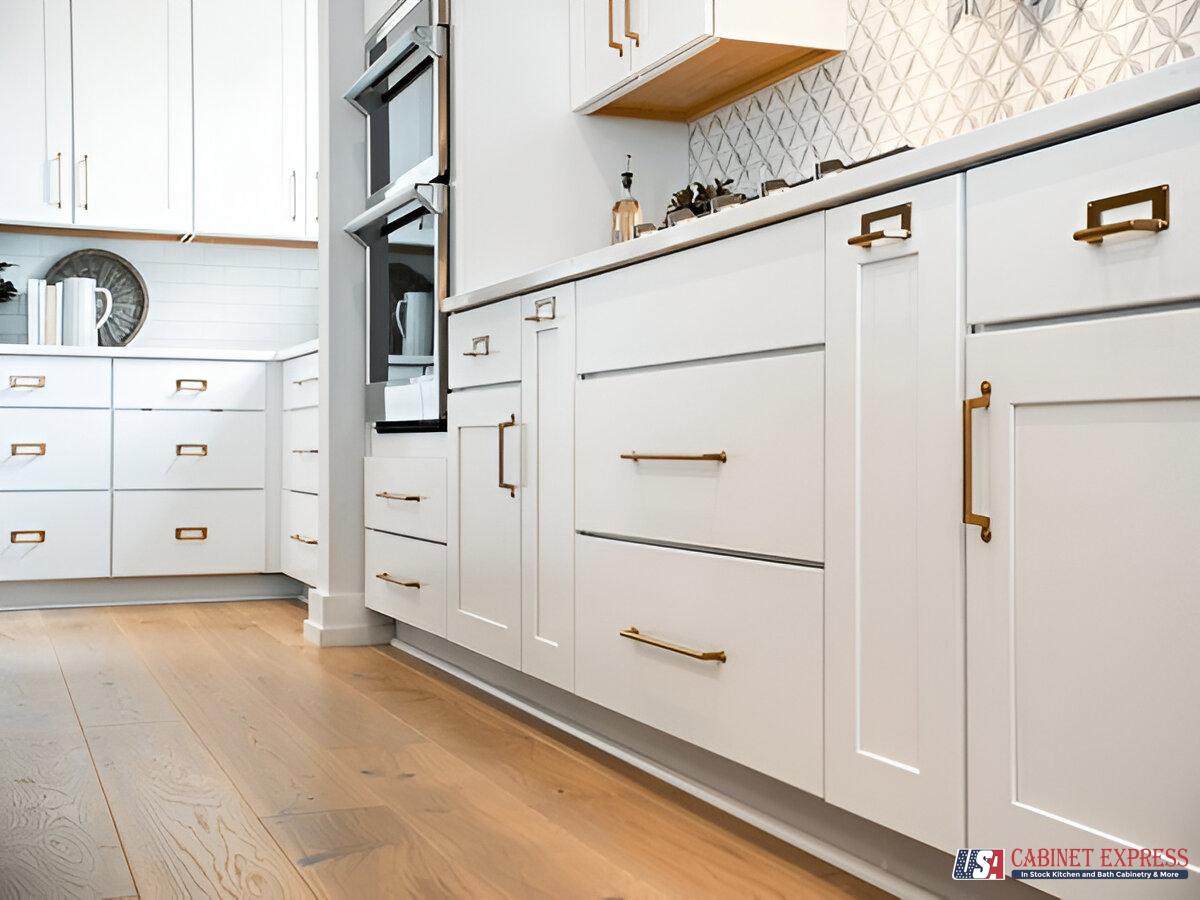 a kitchen with white cabinets and hardwood floors